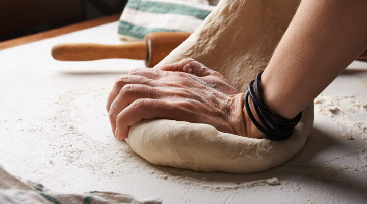 person kneading bread