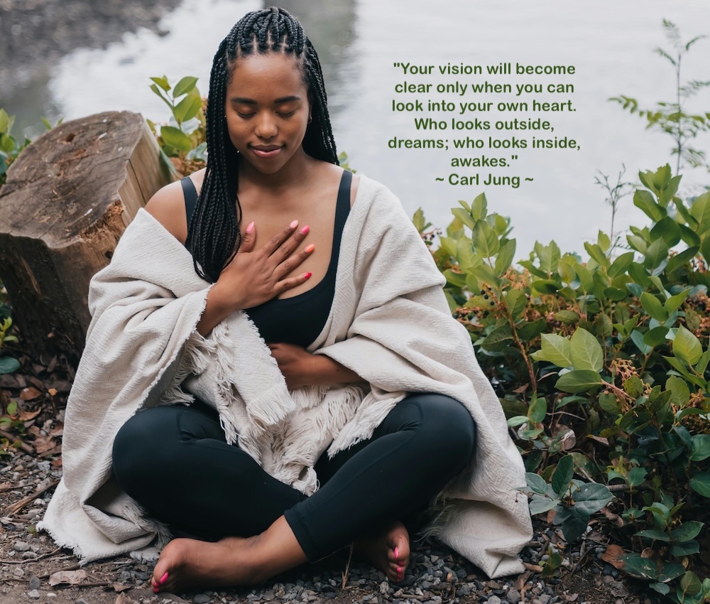 An image of a woman meditating with the quote "Your vision will become clear only when you can look into your own heart. Who looks outside, dreams; who looks inside, awakes." - Carl Jung